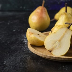 peras al vino preparación, peras cortadas sobre plato de madera